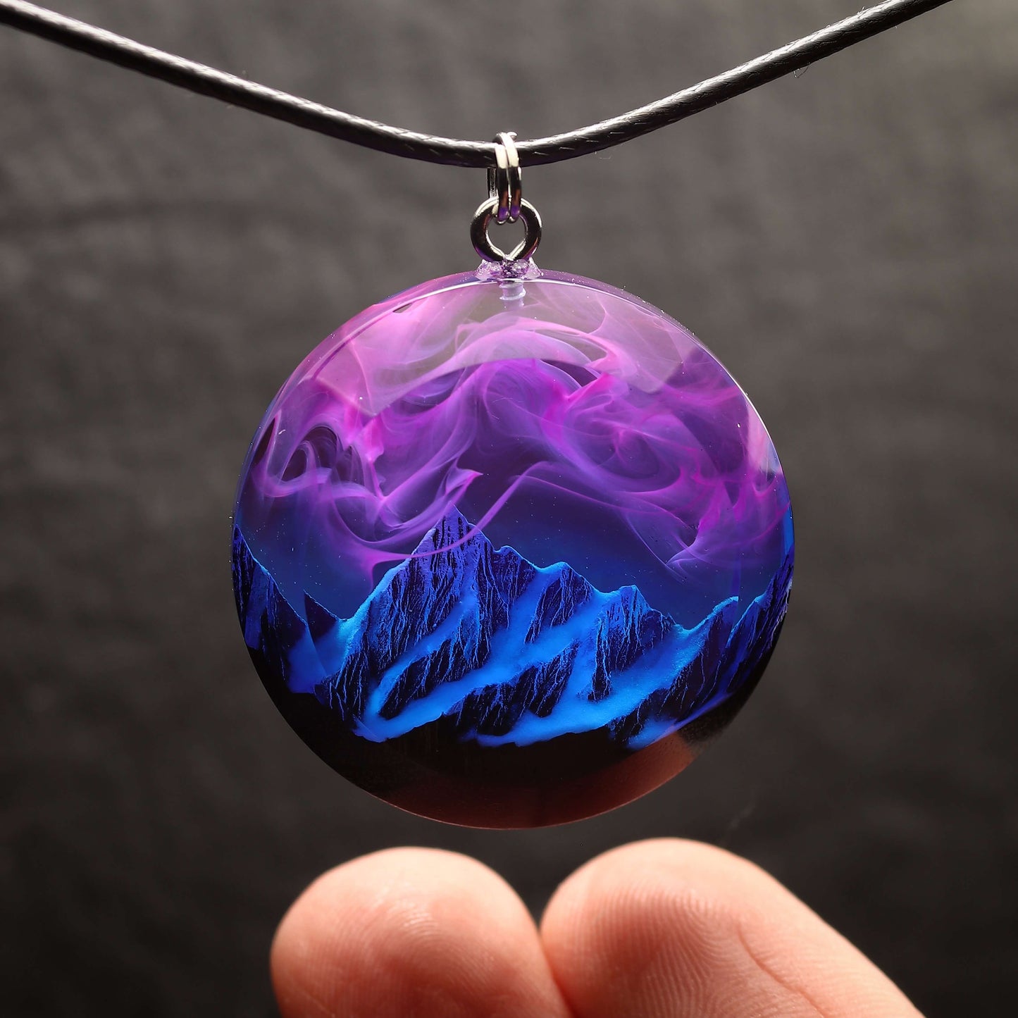 Wood resin necklace with purple and pink nebula sky over blue snowy mountains, round pendant, handmade galaxy jewelry on black cord