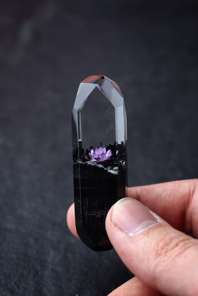 Hand holding handmade resin and wood USB stick with flower