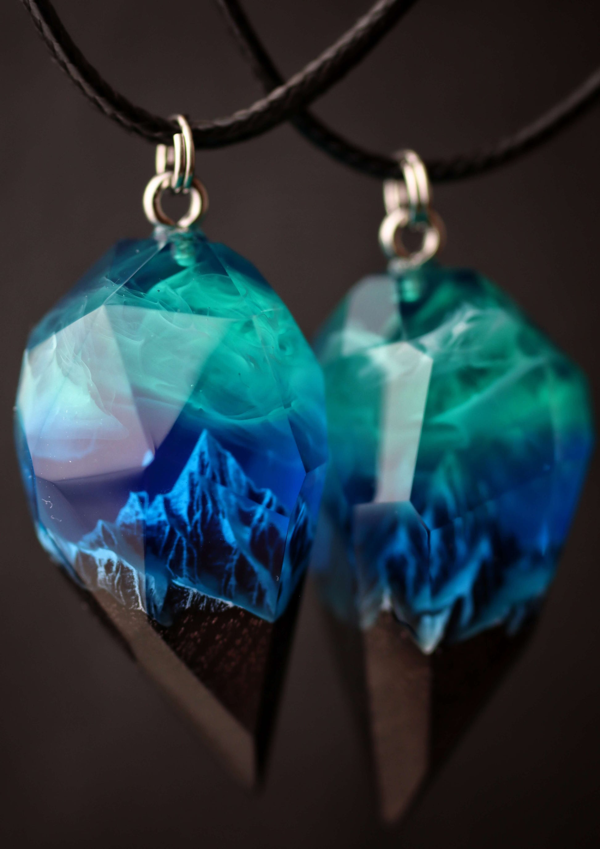 Pair of resin wood heart pendants glowing in blue northern lights style