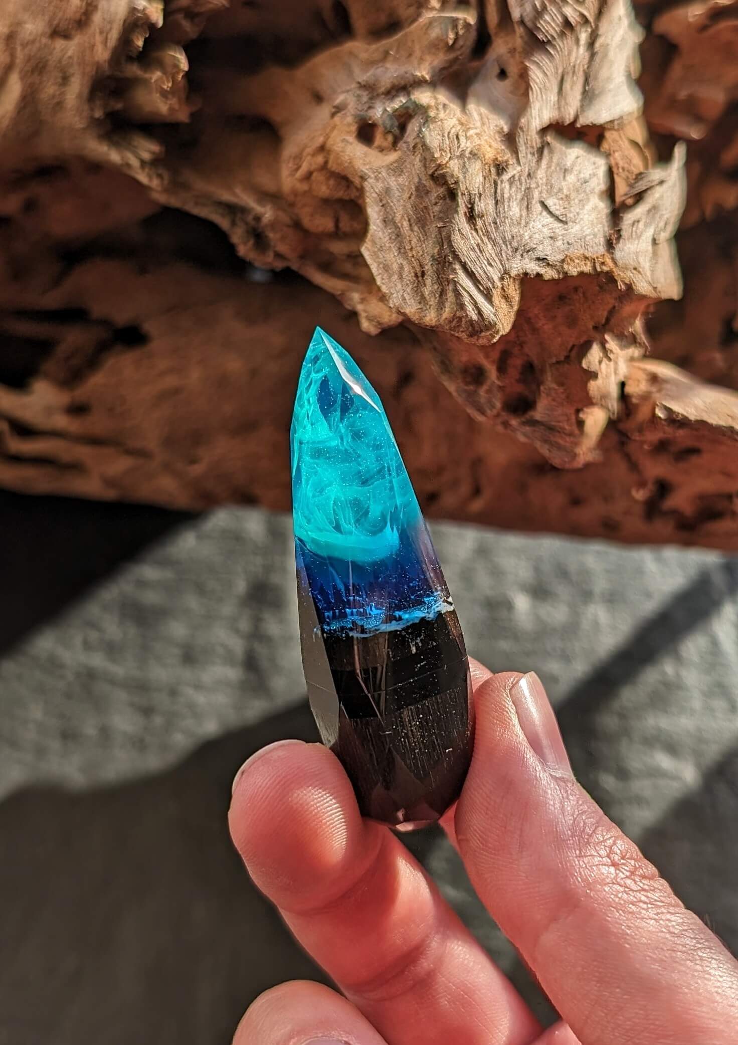 Hand holding handmade wood resin USB stick with northern lights effect