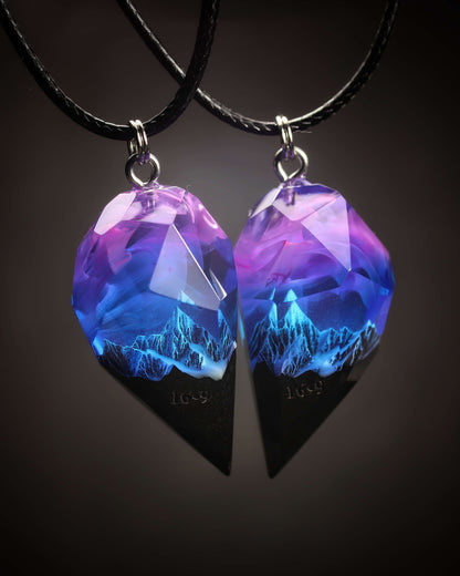 Couple resin and wood pendants with mountain design under purple sky