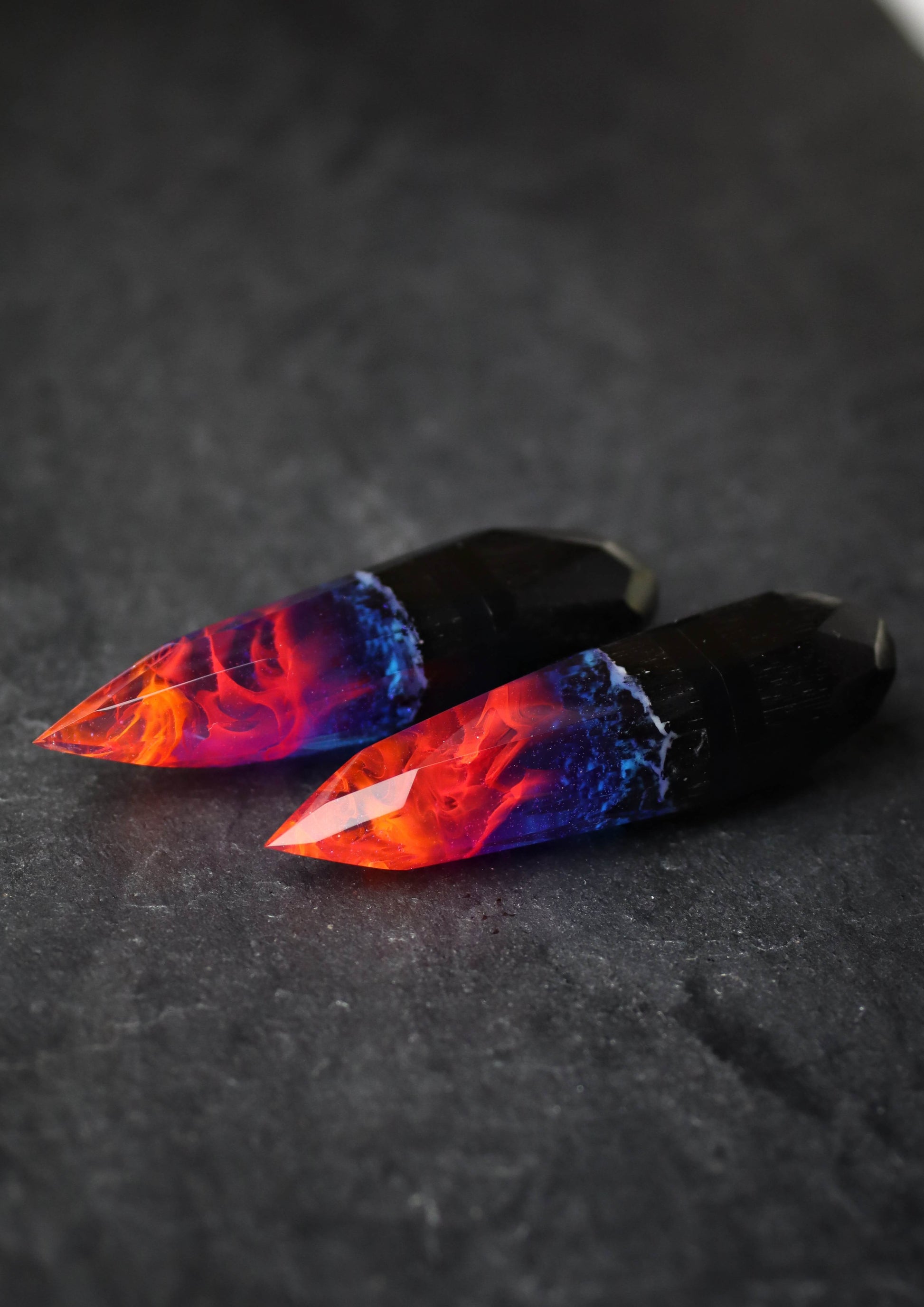 Crystal-shaped resin pendants with flame effect and dark wood base