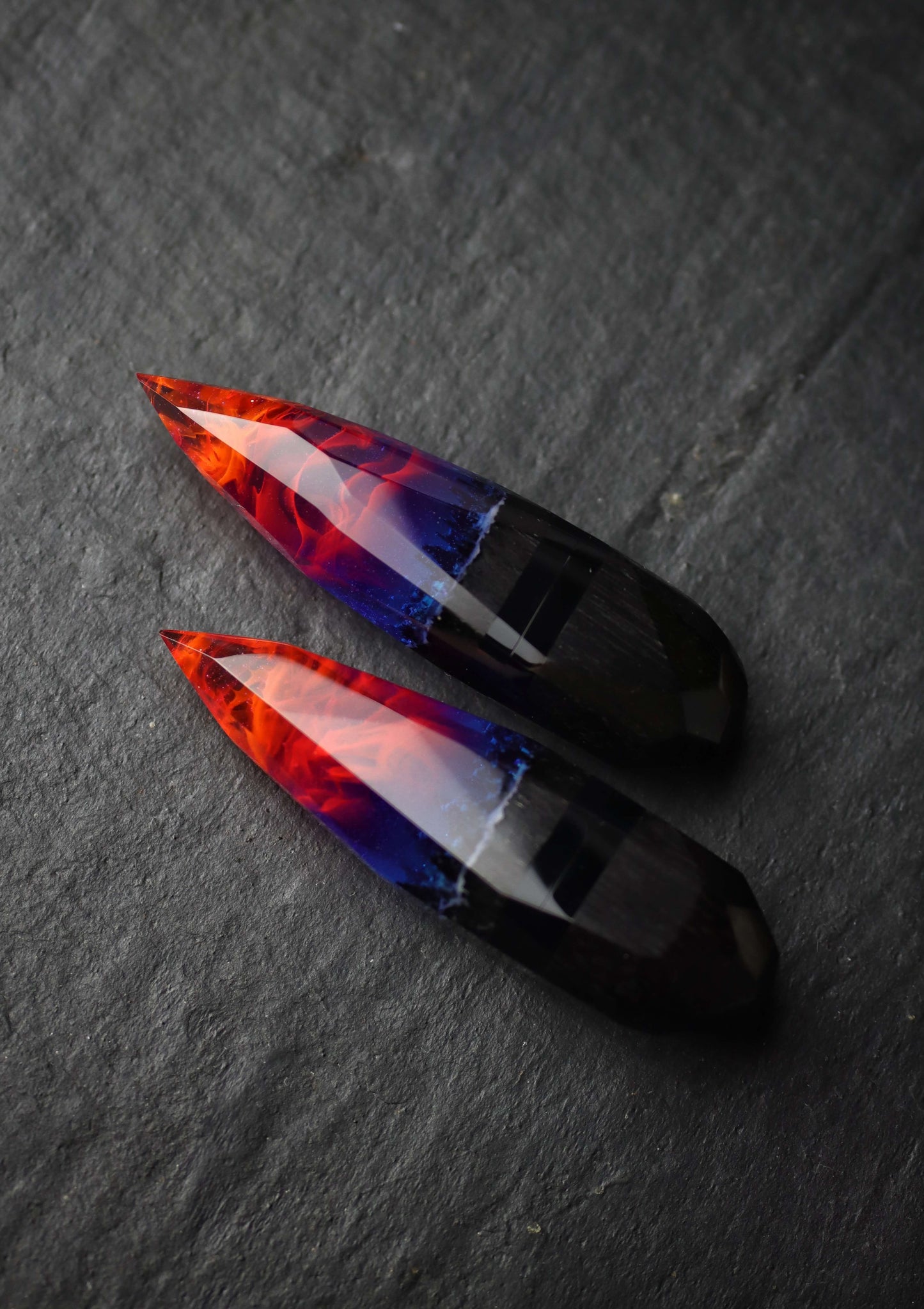 Crystal-shaped resin pendants with flame effect and dark wood base