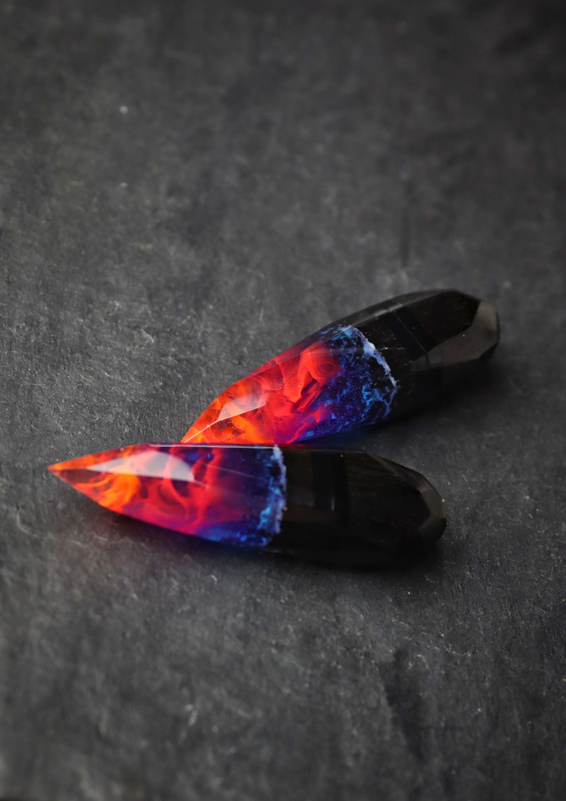 Crystal-shaped resin pendants with flame effect and dark wood base