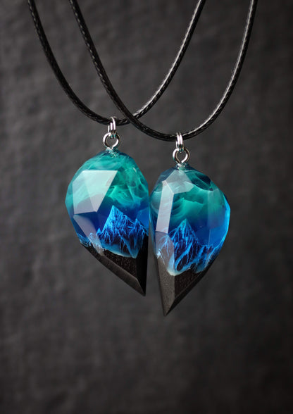 Pair of resin wood heart pendants glowing in blue northern lights style