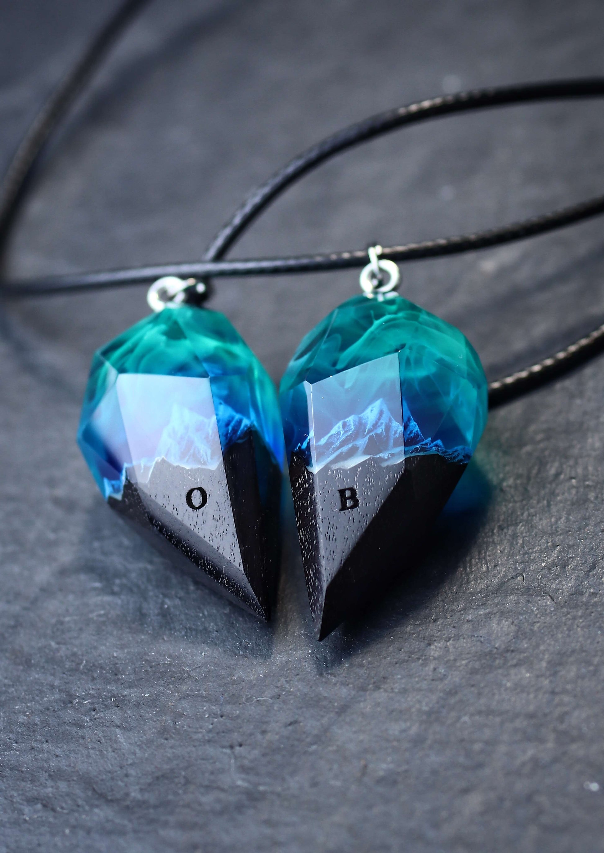 Pair of resin wood heart pendants glowing in blue northern lights style