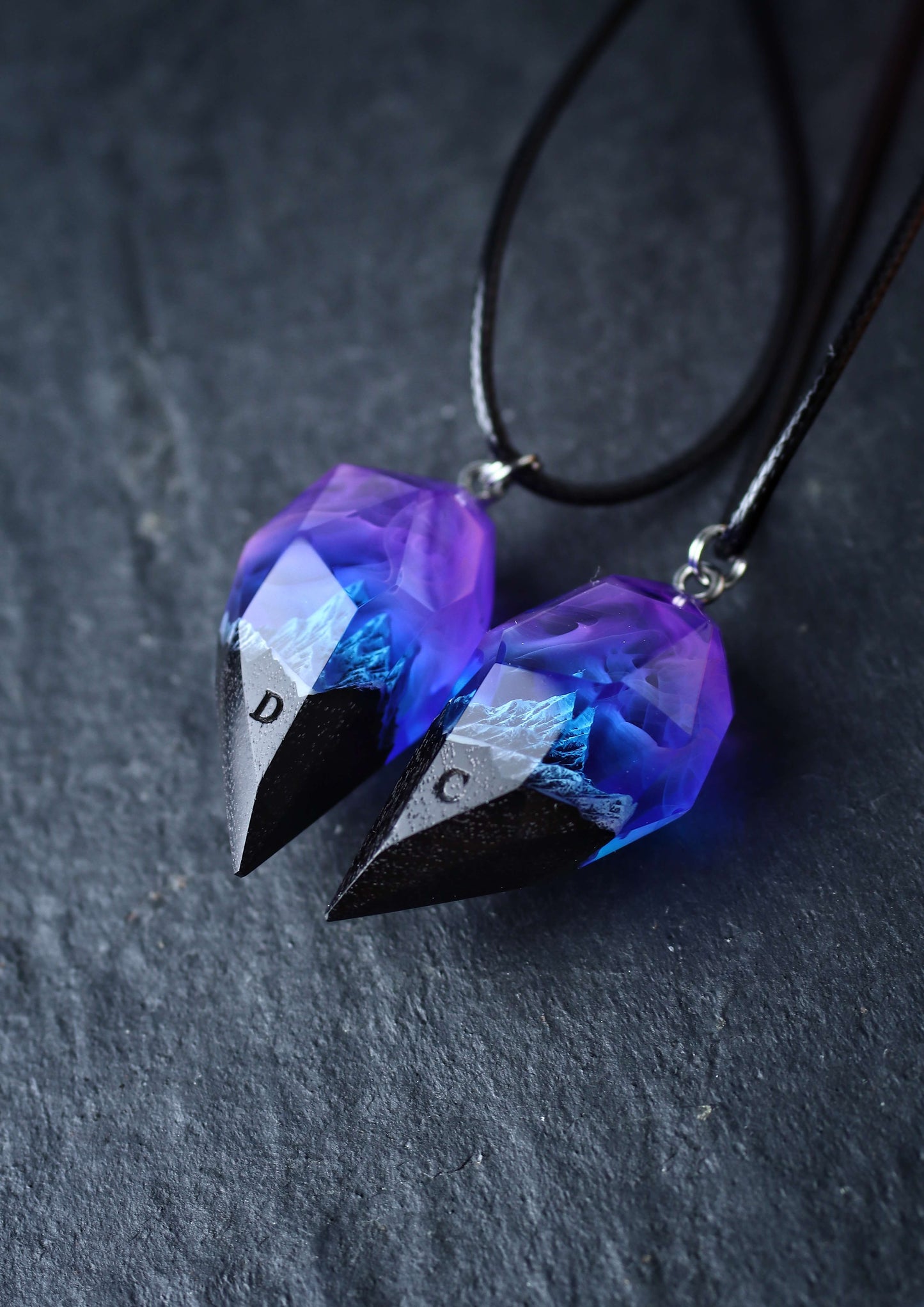 Couple resin and wood pendants with mountain design under purple sky