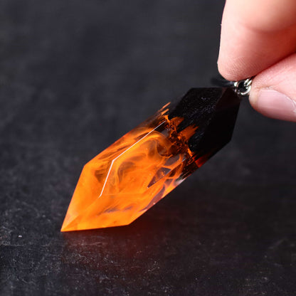 Wood resin necklace with orange fire design inside a Crystal-shaped pendant, handmade flame jewelry on black cord