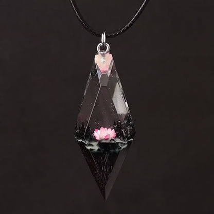Wood resin necklace with pink lotus flower inside a rhombus crystal-shaped pendant, handmade jewelry on black cord